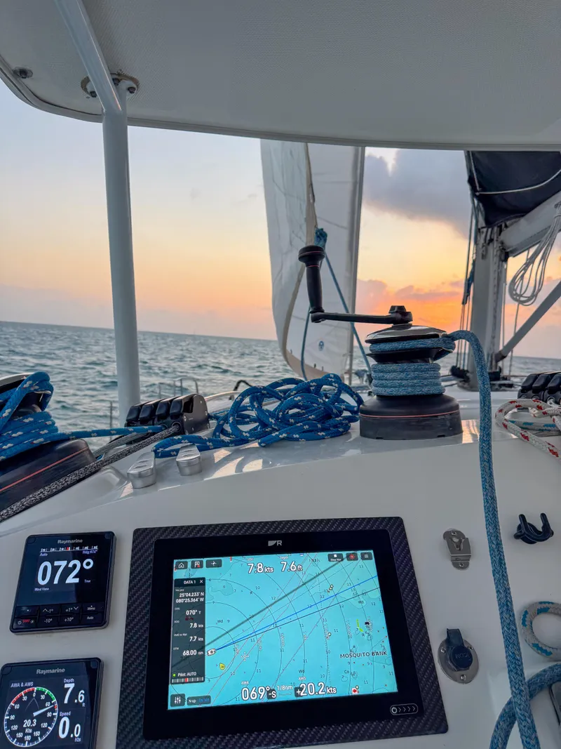 Slide: The Image of Sailing on a 2011 Lagoon 400 catamaran at sunset, featuring navigation instruments. - 63