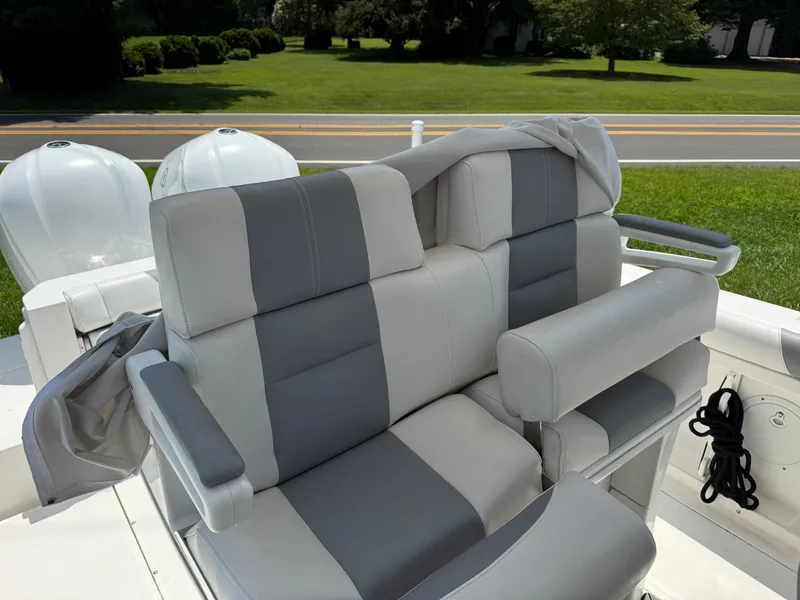 Slide: The Image of 2018 Everglades 255 Center Console boat seats with gray upholstery and armrests. - 6