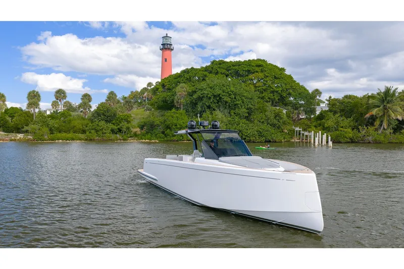 Slide: The Image of 2024 Pardo Yachts 43 cruising near a lush island with a lighthouse in the background. - 2