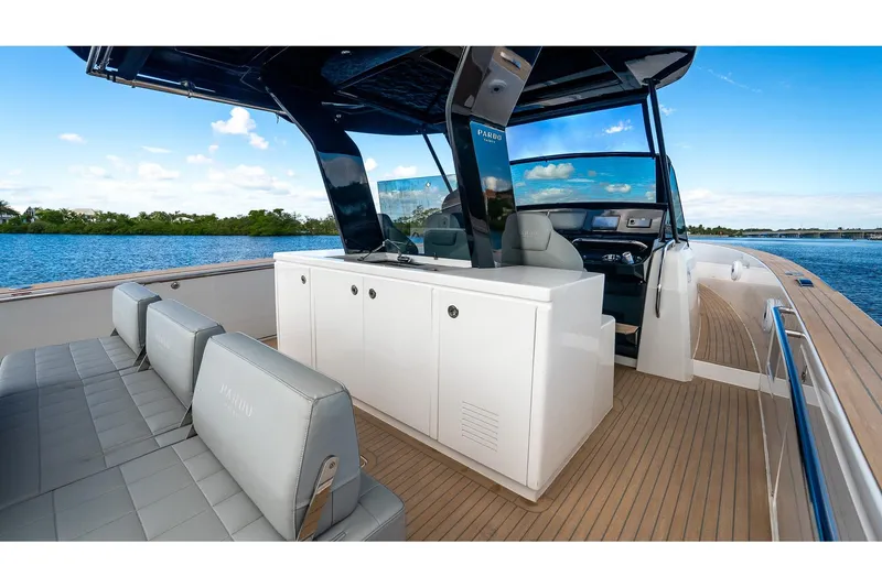 Slide: The Image of 2024 Pardo Yachts 43 interior with sleek seating and modern helm, cruising on a serene waterway. - 23