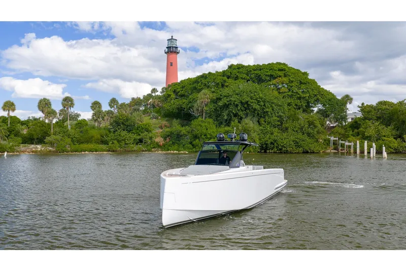 Slide: The Image of 2024 Pardo Yachts 43 cruising near a scenic lighthouse and lush greenery. - 4