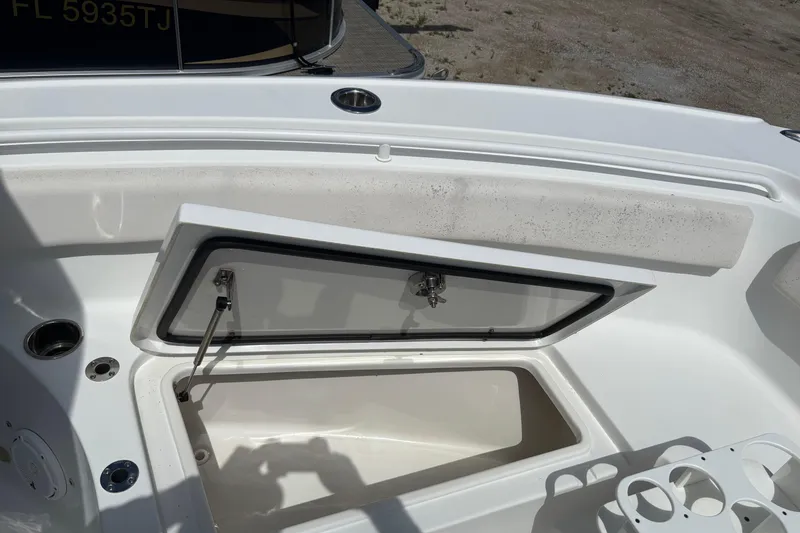 Slide: The Image of 2021 Sea Hunt Ultra 265 SE boat storage compartment open, showing interior details. - 12