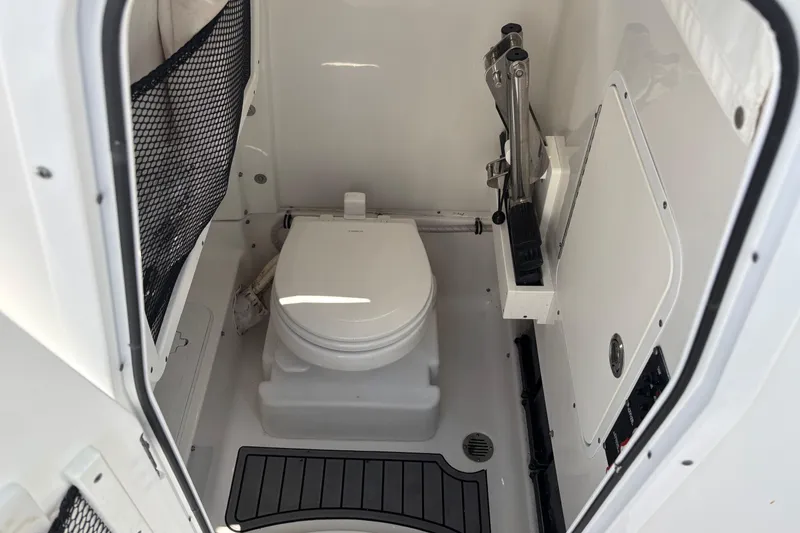 Slide: The Image of 2021 Sea Hunt Ultra 265 SE boat interior with compact marine toilet. - 14