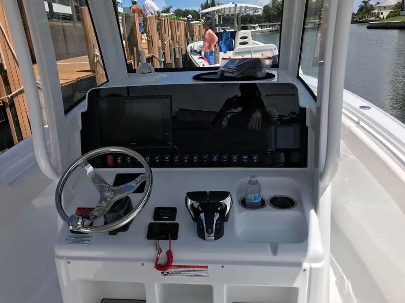 Slide: The Image of 2021 Sea Hunt Ultra 265 SE boat console with steering wheel and controls. - 4