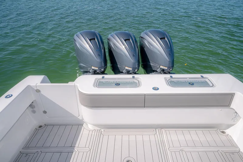 Slide: The Image of Contender 44ST 2020 boat with triple outboard motors on calm water. - 10