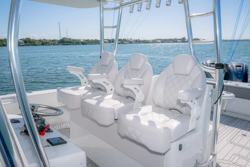 Slide: The Image of 2020 Contender 44ST boat interior with three white captain's chairs on a sunny day. - 15