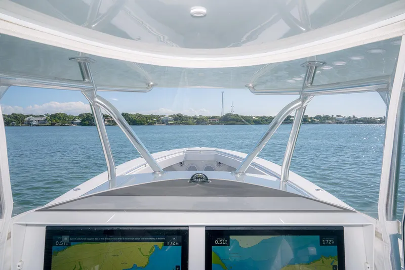 Slide: The Image of 2020 Contender 44ST boat helm with dual navigation screens on calm water. - 17