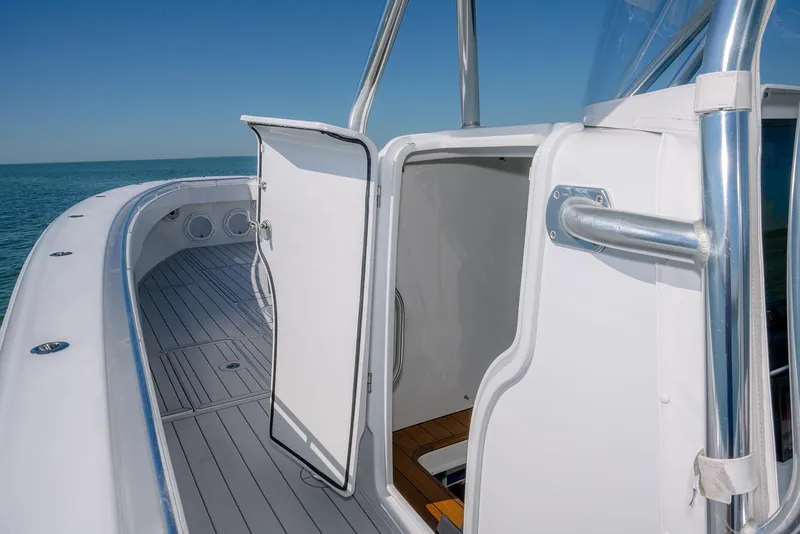 Slide: The Image of 2020 Contender 44ST boat with open cabin door, sleek deck, and ocean view. - 22