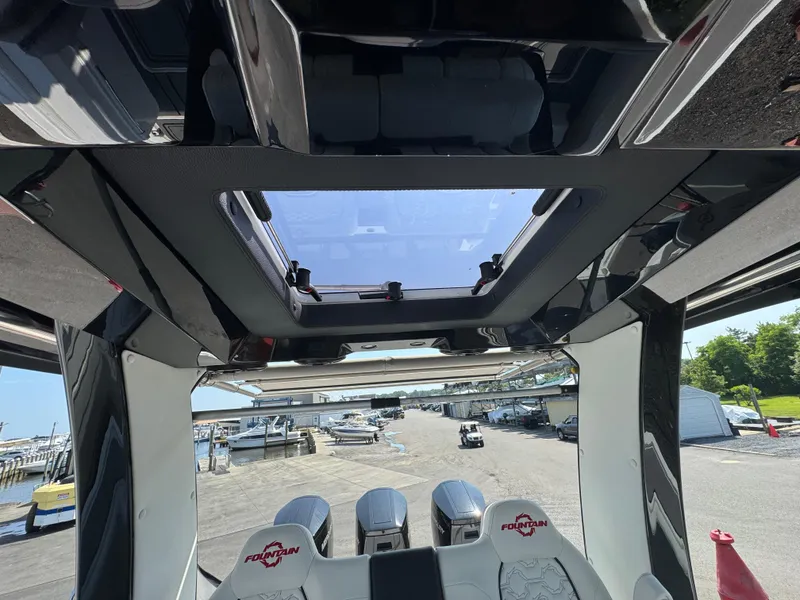 Slide: The Image of Interior view of 2025 Fountain 43 SCX boat with sunroof and marina background. - 10