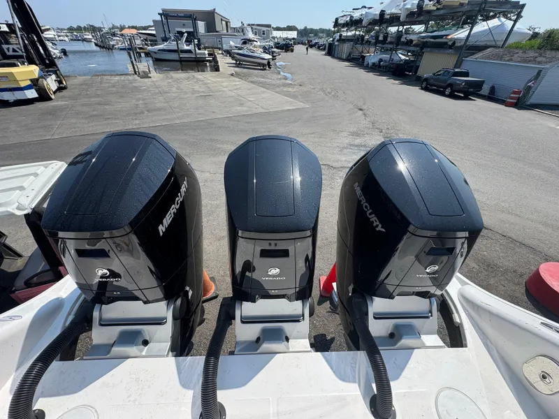 Slide: The Image of Three Mercury Verado outboard engines on a 2025 Fountain 43 SCX boat at a marina. - 3