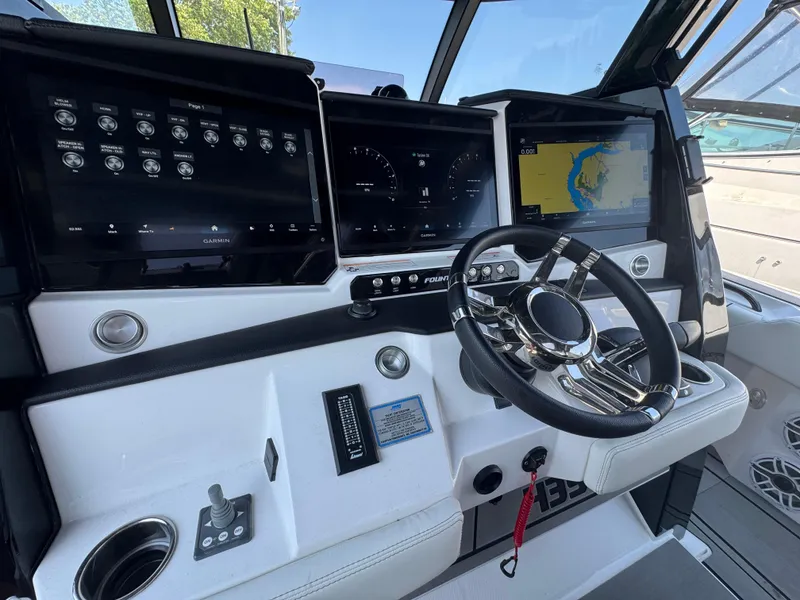 Slide: The Image of 2025 Fountain 43 SCX boat dashboard with advanced navigation screens and steering wheel. - 4