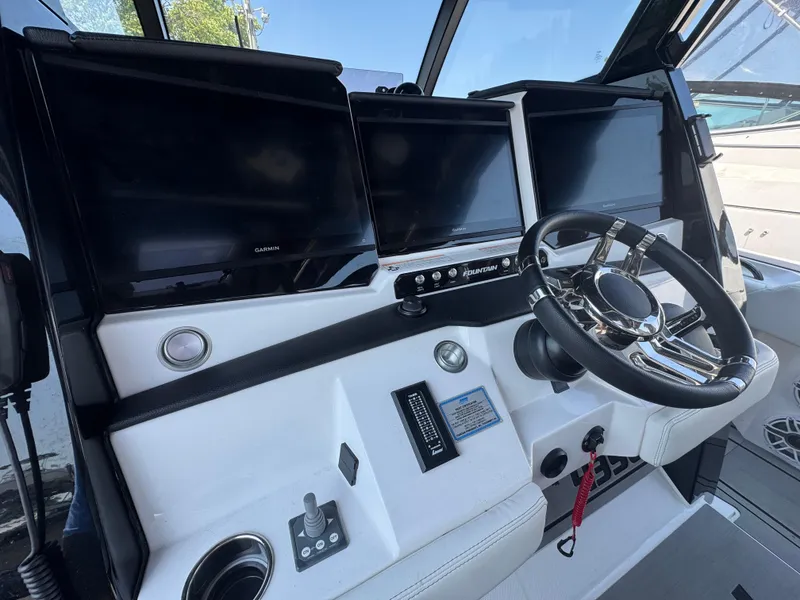 Slide: The Image of 2025 Fountain 43 SCX boat cockpit with modern steering and multiple Garmin displays. - 6