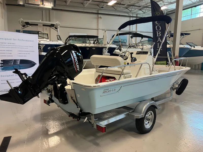 Slide: The Image of 2026 Boston Whaler 150 Montauk boat displayed indoors with Mercury engine. - 4