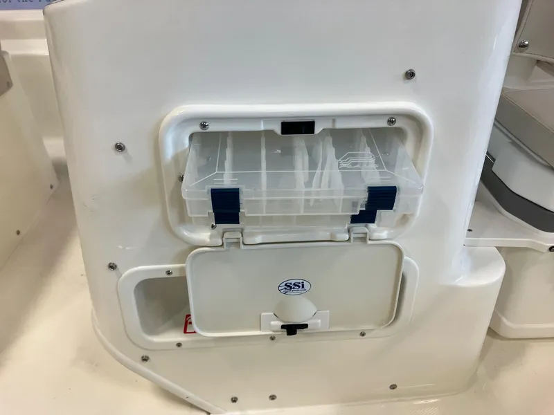 Slide: The Image of Storage compartment on a 2026 Boston Whaler 150 Montauk boat, featuring a clear plastic container. - 8