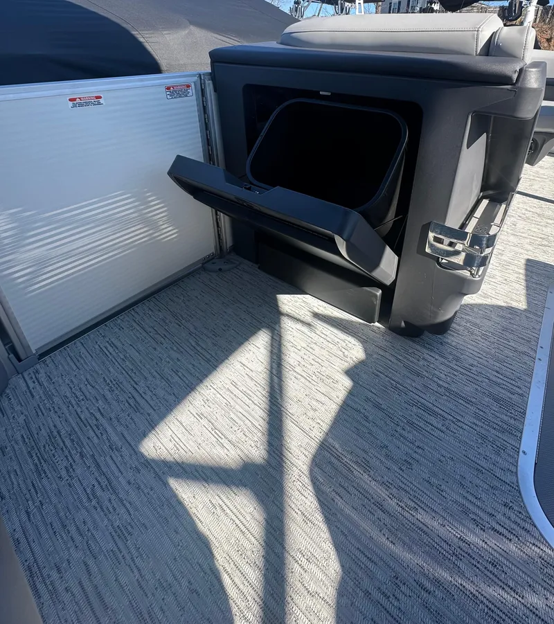 Slide: The Image of 2025 Bennington 24 MFB boat interior with open storage compartment and textured flooring. - 11