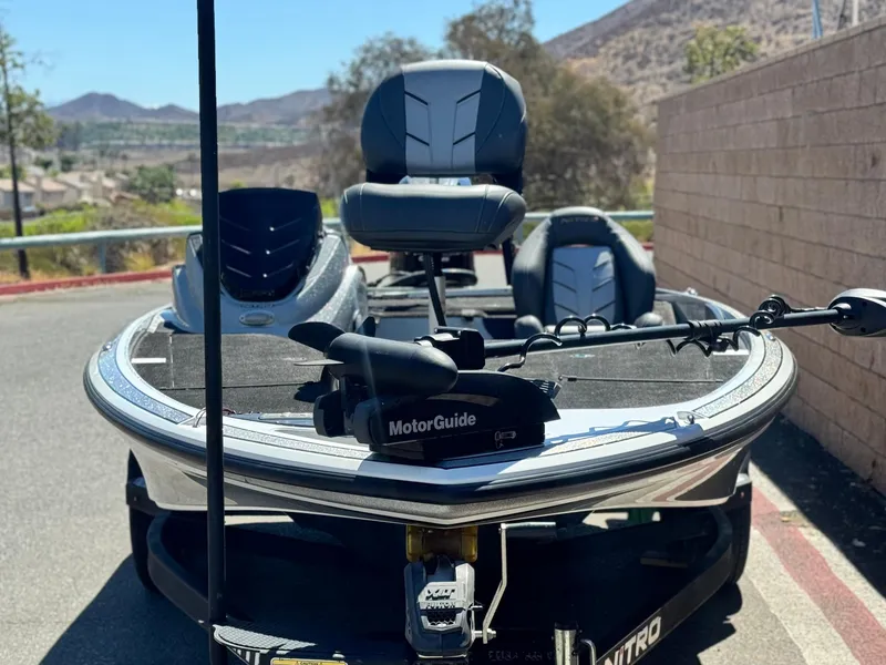 Slide: The Image of 2017 Tracker Nitro Z19 boat with MotorGuide trolling motor, parked outdoors. - 2
