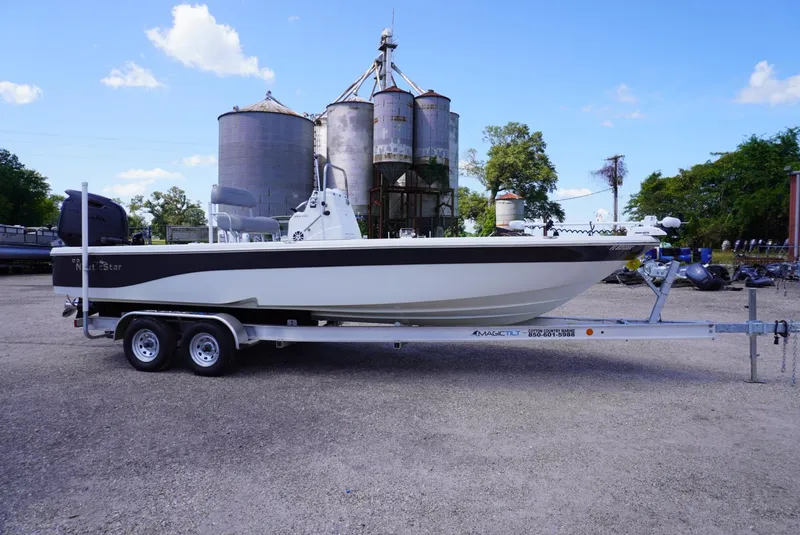 The Image of 2014 NauticStar 244 XTS boat on trailer, industrial background, clear sky. - 0