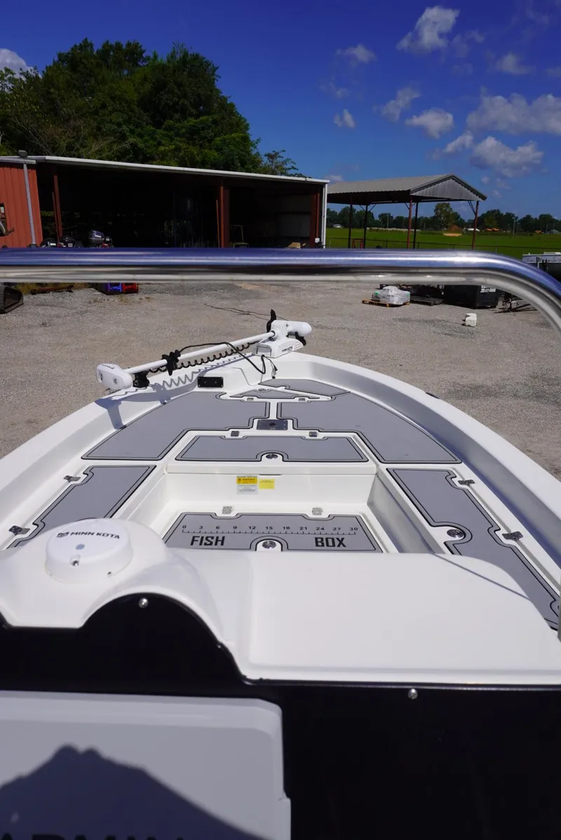 Slide: The Image of 2014 NauticStar 244 XTS boat with fish box, parked outdoors under blue sky. - 3