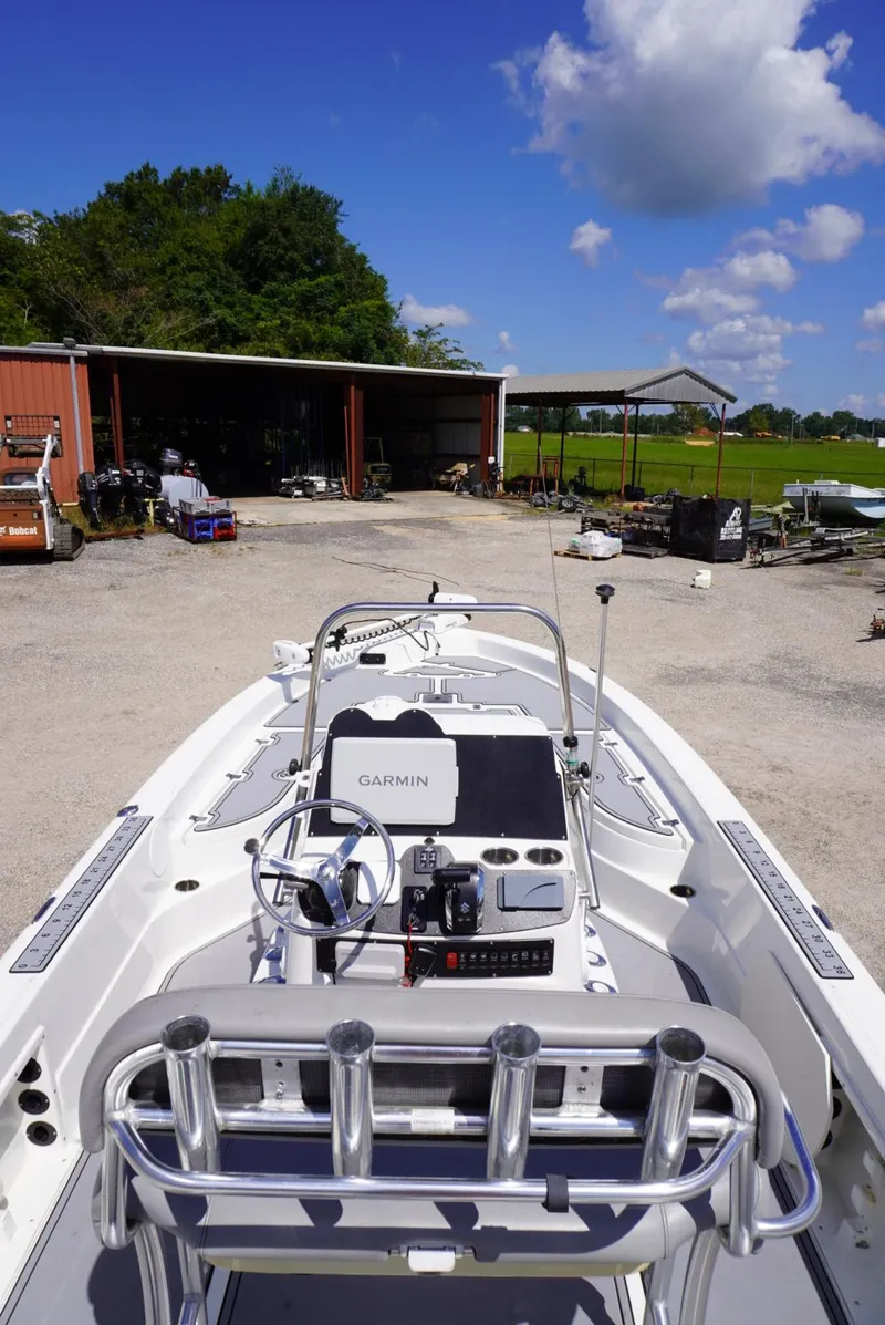 Slide: The Image of 2014 NauticStar 244 XTS boat with Garmin system, parked outdoors under blue sky. - 8