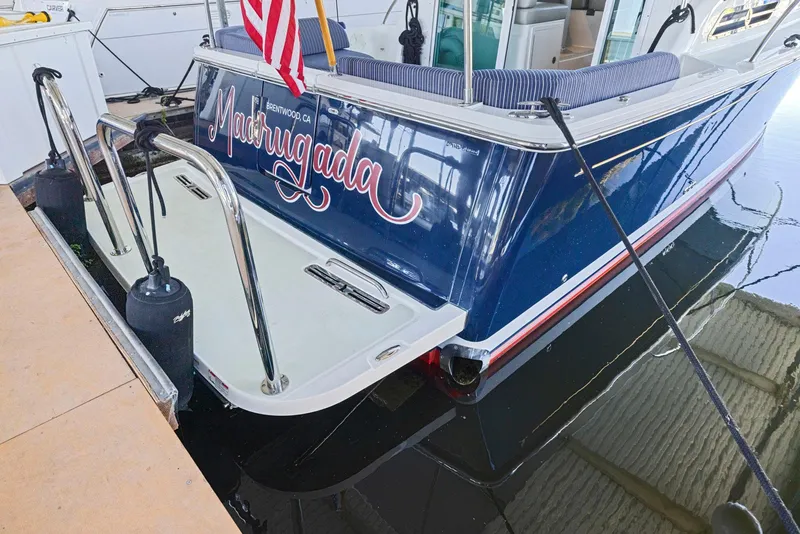 Slide: The Image of 2018 Back Cove 32 boat docked, displaying "Madrugada" and American flag. - 12