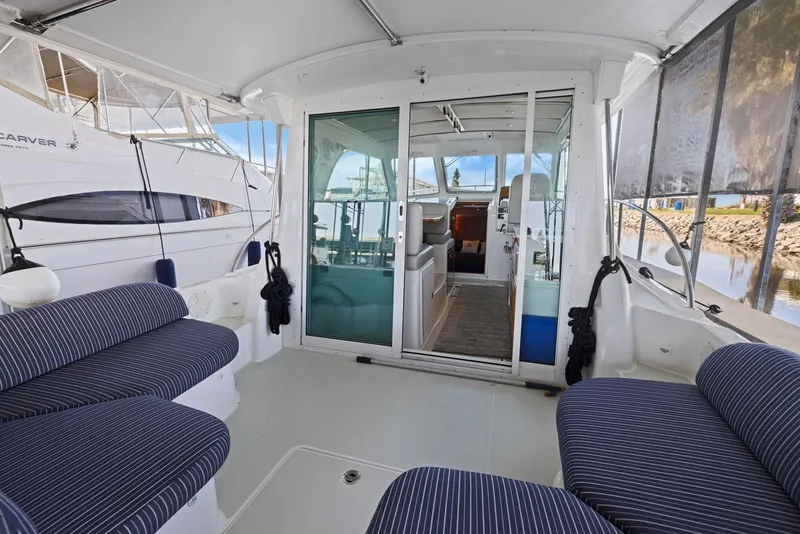 Slide: The Image of 2018 Back Cove 32 boat interior with striped seating and sliding glass doors. - 14
