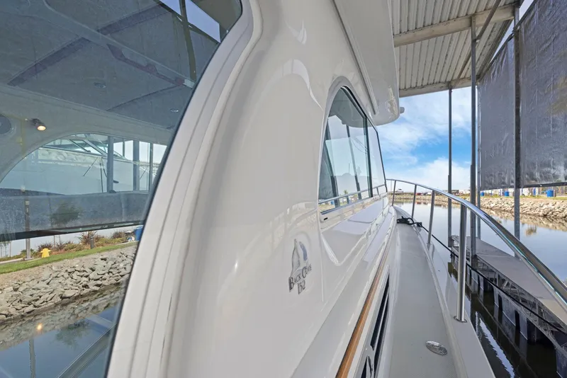 Slide: The Image of 2018 Back Cove 32 yacht docked, showcasing sleek design and reflective windows. - 15