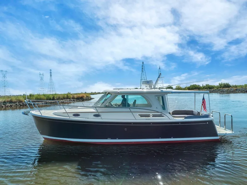 Slide: The Image of 2018 Back Cove 32 boat on calm water under a clear blue sky. - 22