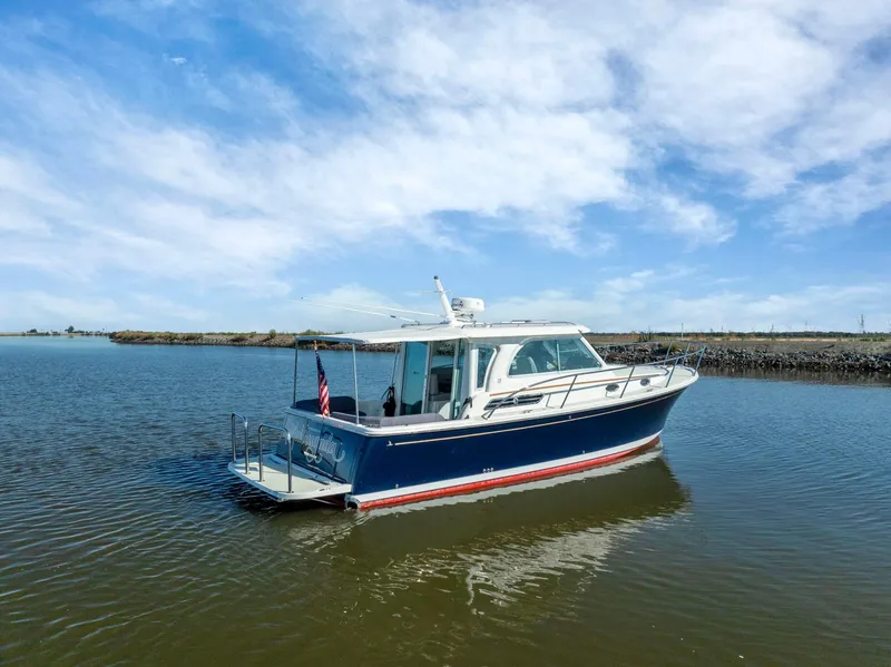 Slide: The Image of 2018 Back Cove 32 boat on calm water under a clear blue sky. - 25