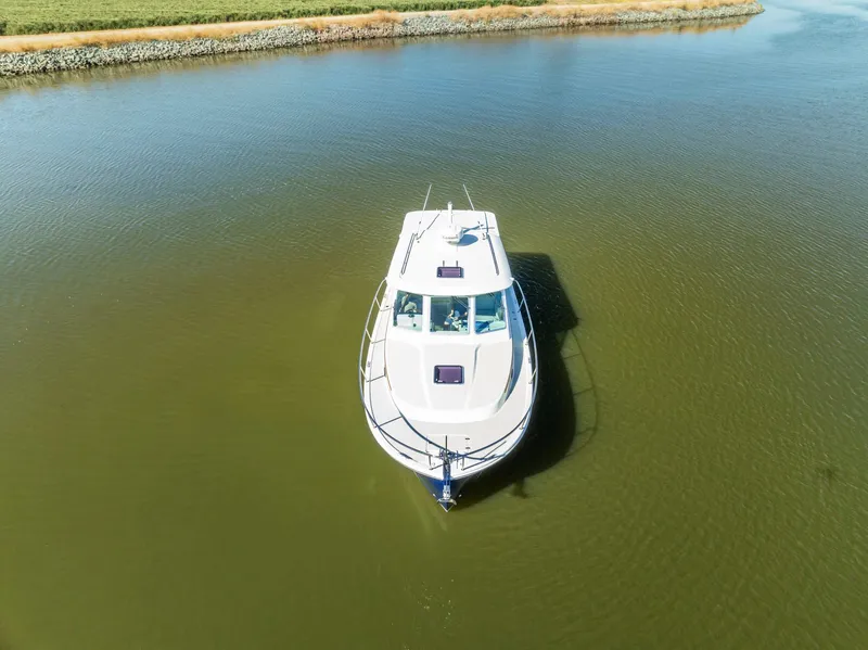 Slide: The Image of 2018 Back Cove 32 boat cruising on a calm river. - 29