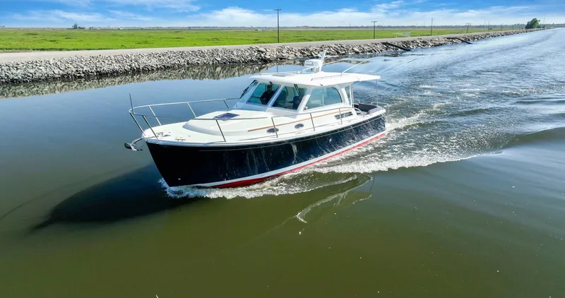 Slide: The Image of 2018 Back Cove 32 cruising on a calm river under a clear blue sky. - 38