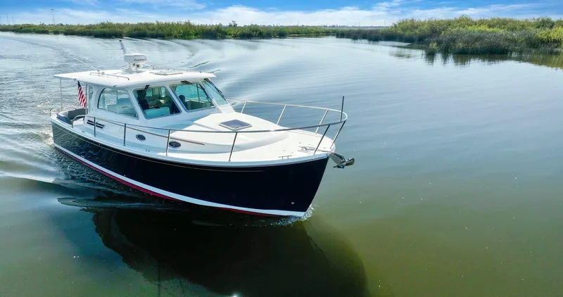 Slide: The Image of 2018 Back Cove 32 cruising on a calm river under a clear blue sky. - 39
