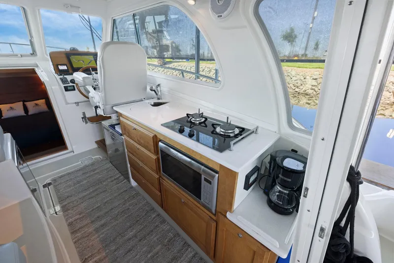 Slide: The Image of Interior of 2018 Back Cove 32 yacht featuring kitchen and helm station. - 43