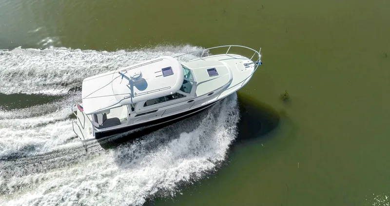 Slide: The Image of 2018 Back Cove 32 cruising on calm water, aerial view. - 8
