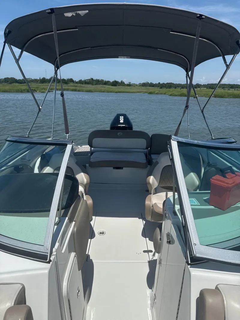 Slide: The Image of 2023 Crownline Eclipse E235 XS boat with canopy on a calm lake. - 10