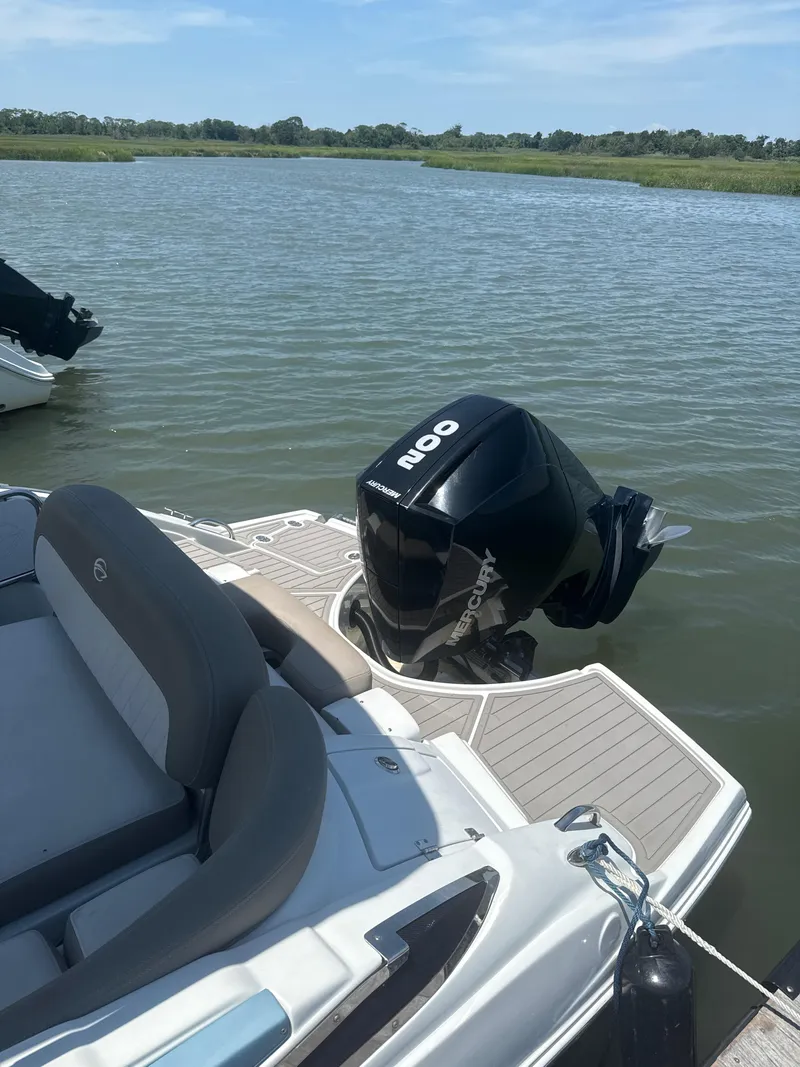 Slide: The Image of 2023 Crownline Eclipse E235 XS boat with Mercury outboard motor on calm water. - 14