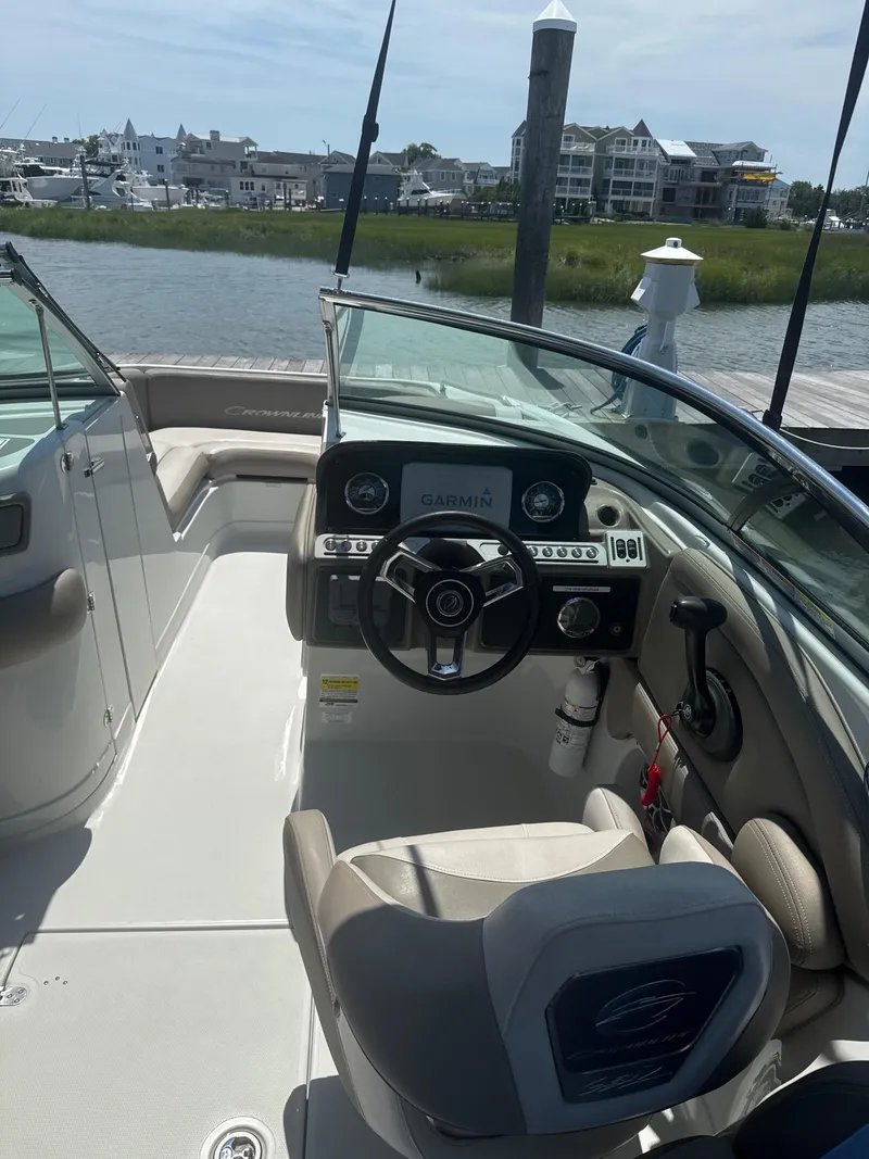 Slide: The Image of 2023 Crownline Eclipse E235 XS boat interior with steering wheel and Garmin navigation system. - 7
