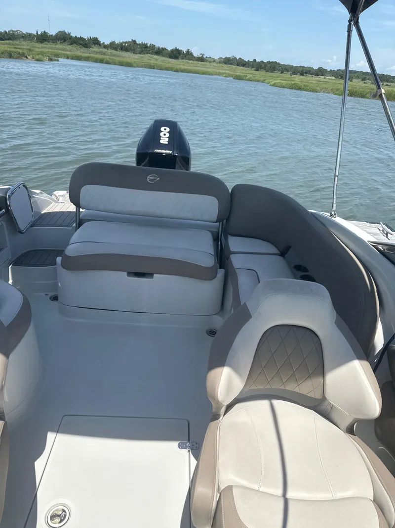 Slide: The Image of 2023 Crownline Eclipse E235 XS boat interior with seating, on a calm lake. - 8