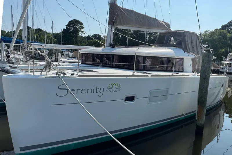 Slide: The Image of 2016 Lagoon 400 S2 catamaran named "Serenity" docked at a marina. - 0