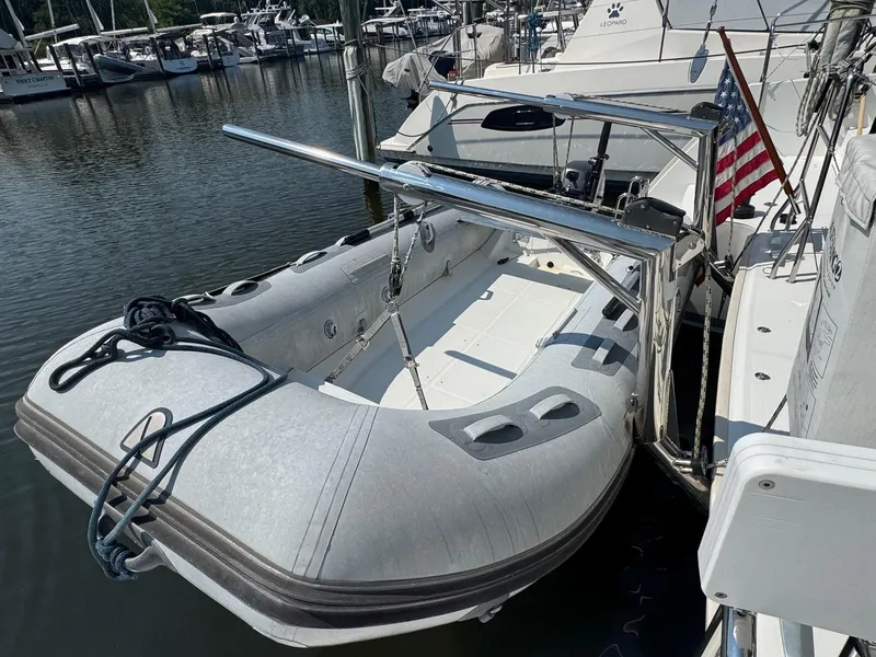 Slide: The Image of Inflatable dinghy docked beside a 2016 Lagoon 400 S2 catamaran with an American flag. - 21