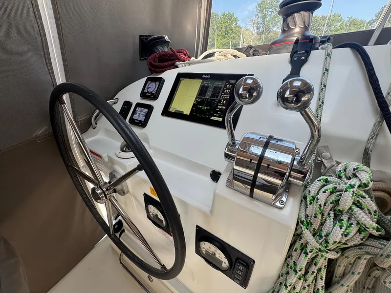 Slide: The Image of Helm of 2016 Lagoon 400 S2 catamaran with navigation controls and steering wheel. - 4