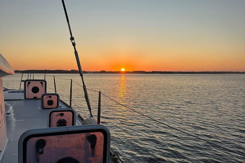 Slide: The Image of Sunset view from a 2016 Lagoon 400 S2 catamaran on calm waters. - 77