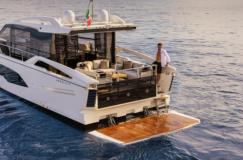 Slide: The Image of 2024 Absolute 48 Coupe luxury yacht on the water with a man on the deck. - 4