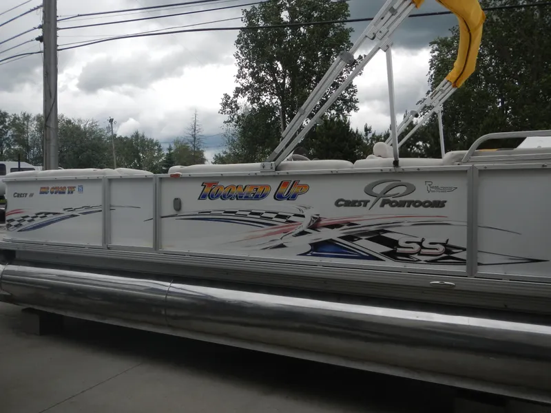 Slide: The Image of 2010 Crest III pontoon boat with "Tooned Up" graphics and Crest Pontoons branding. - 0