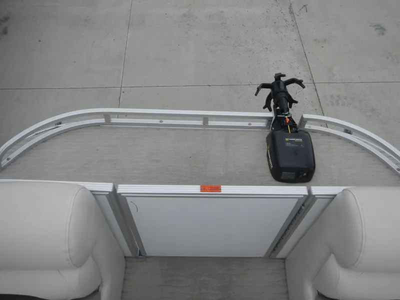 Slide: The Image of Pontoon boat deck with motor, Crest III 2010 model, featuring beige seating and aluminum railing. - 16