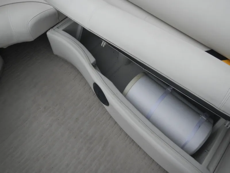 Slide: The Image of Open storage compartment in a 2010 Crest III boat with white seating. - 20
