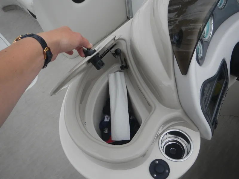 Slide: The Image of Hand opening storage compartment on 2010 Crest III boat dashboard. - 22