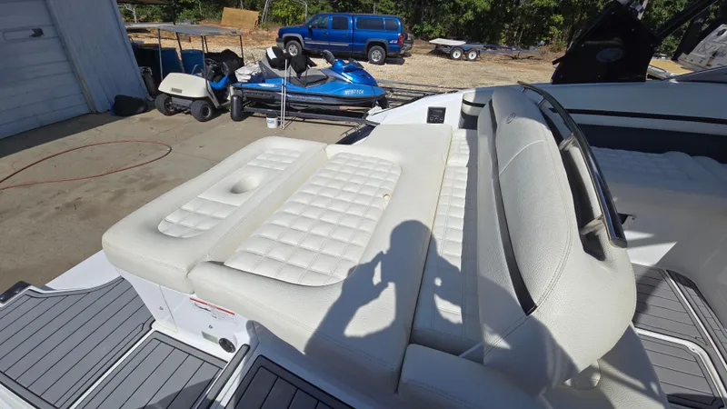 Slide: The Image of 2017 Cobalt R5 WSS Surf boat with white cushioned seating in a marina setting. - 17