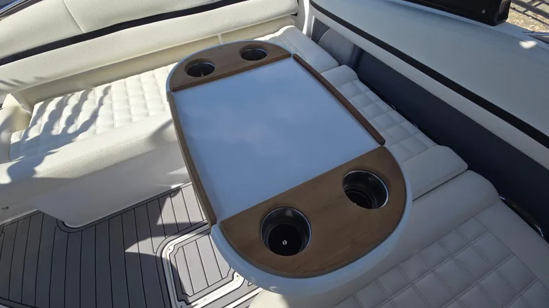 Slide: The Image of 2017 Cobalt R5 WSS Surf boat interior with cushioned seating and a wooden table with cup holders. - 48