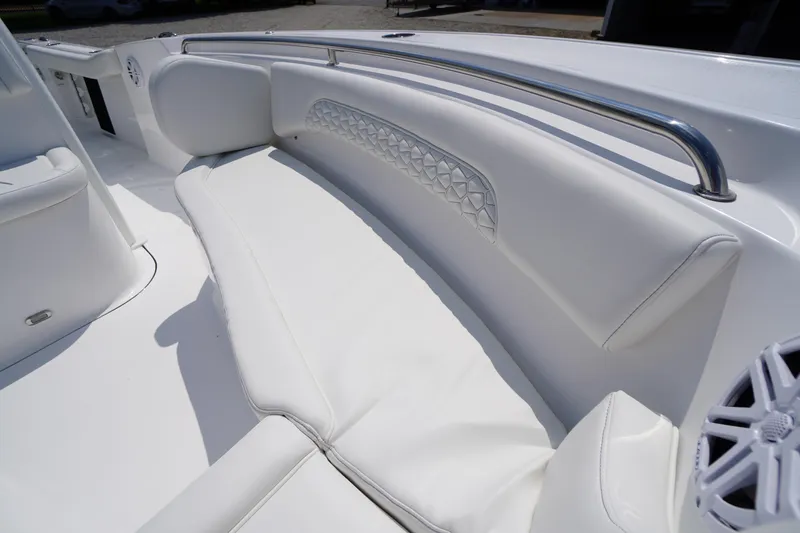 Slide: The Image of 2026 Tidewater 232 CC Adventure boat interior with white cushioned seating and stainless steel railing. - 11