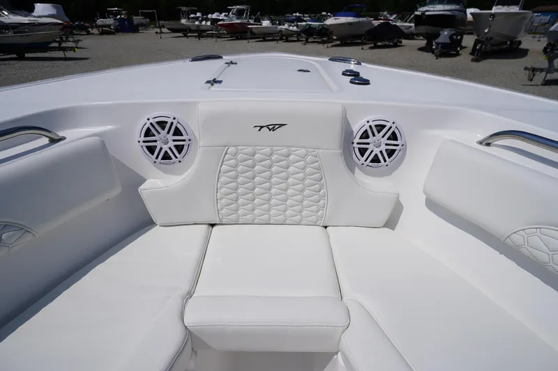 Slide: The Image of 2026 Tidewater 232 CC Adventure boat interior with white seating and speakers. - 12